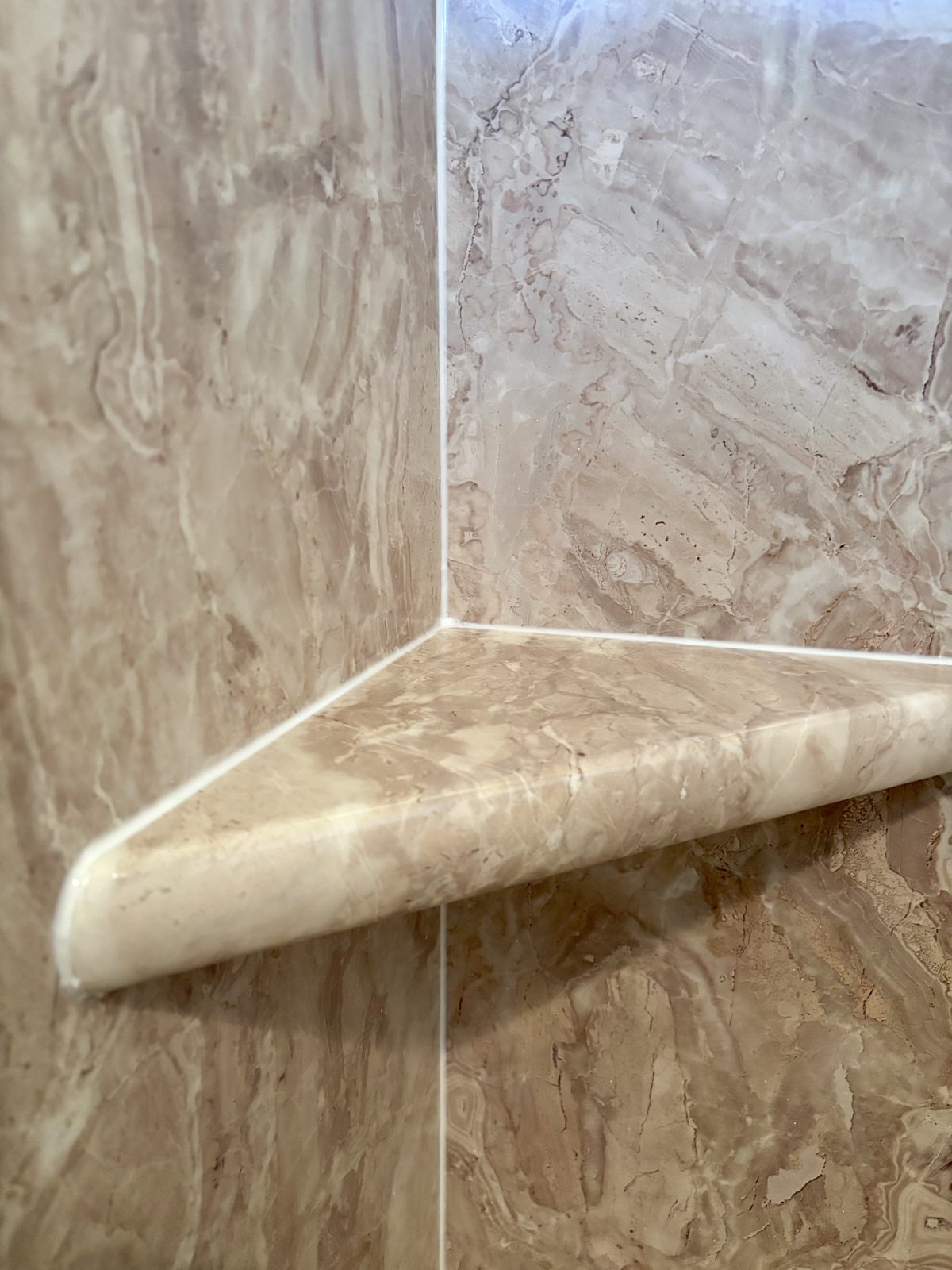 Close-up of the corner shelf in the new marble-look shower surround